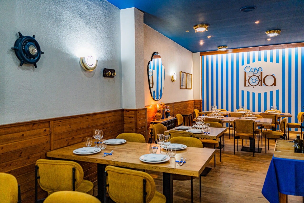 Sala de Casa Lola con la pared de rayas azules y blancas